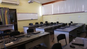 There is a whiteboard mounted on the back wall of the lab, which is pale yellow brick.